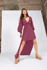 Vestido largo color borgoña, con escote en V, mangas largas abullonadas con puños elásticos, abertura en la cintura y falda con capas y abertura lateral.