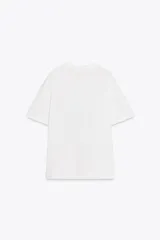 Camiseta blanca de corte recto y manga corta, con cuello redondo. Estampado frontal con dos mujeres en la playa y texto "Beach Days Best Days".