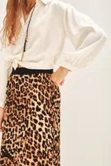 Falda midi plisada con estampado animal print de leopardo en tonos marrones y negros, con cintura elástica negra.