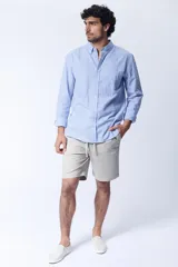 Camisa celeste a rayas verticales blancas, de corte clásico, con cuello abotonado y bolsillo en el pecho.