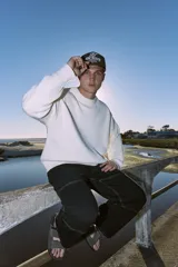 Sweater blanco de tejido plano, con cuello redondo, corte oversize y hombros caídos.