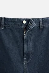 Pantalón de jean azul oscuro, corte recto, confeccionado en denim de algodón y lyocell. Cuenta con bolsillos frontales y traseros de vivo. Cierre frontal con cremallera y botón.
