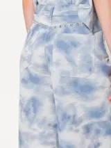 Pantalón de jean de corte wide con cinco bolsillos, estampado tie-dye celeste y blanco.