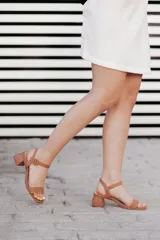 Sandalias de tacón bajo color beige con textura símil piel de serpiente. Tienen una tira delgada sobre los dedos y una pulsera con hebilla al tobillo.