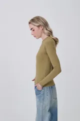 Remera de manga larga ajustada al cuerpo, color negro, con cuello redondo a la base y tejido acanalado.