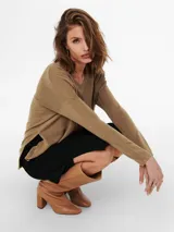 Sweater color marrón claro de tejido de punto suave, con cuello en V y mangas largas. Ideal para looks casuales o formales.
