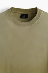 Remera de algodón color verde con efecto desteñido, corte amplio, cuello redondo y mangas cortas.