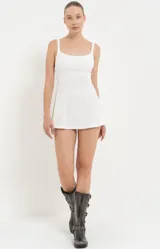 Vestido corto blanco con breteles finos y corte ajustado al cuerpo.