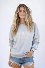 Sudadera gris melange de corte oversize con logo de la marca bordado en el frente y bandera de Uruguay bordada en la manga.