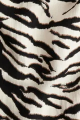 Vestido corto sin mangas con estampado de cebra en blanco y negro, escote redondo y corte evasé.