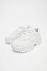 Zapatillas deportivas blancas con plataforma chunky, detalle de pespuntes y cierre con cordones.