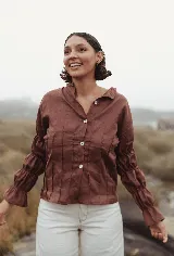 Camisa color beige de lino, corte holgado, manga larga con puños fruncidos y cuello clásico.