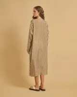 Vestido largo de manga larga con botones en el escote y tajos verticales laterales. Diseño a rayas verticales en tonos marrón y blanco.