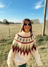Sweater de lana color crudo con cuello alto y diseño geométrico en tonos verde y bordó.