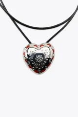 Pack de dos collares: uno metálico plateado con cierre de mosquetón y otro tipo corbata con cordón negro y dije de corazón metálico con detalles en rojo y negro.
