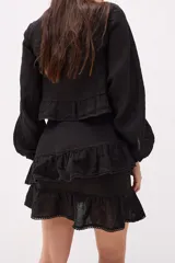 Minifalda marrón con volados superpuestos y terminaciones deshilachadas.