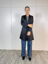 Blazer negro de corte clásico con solapas y bolsillos delanteros.