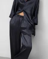 Pantalón ancho de pierna recta, color gris oscuro, confeccionado en acetato con textura arrugada y brillo satinado. Posee cintura elástica ajustable con cordón y bolsillos traseros.
