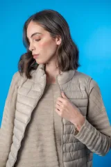 Chaleco acolchado color beige con cierre frontal y cuello alto.