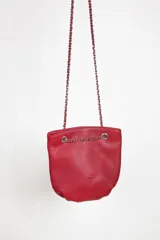 Cartera mini color bordó con correa metálica y cuero, diseñada para llevar lo esencial de manera cómoda.