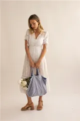 Vestido midi blanco con bordado inglés, escote en V, mangas cortas abullonadas con ajuste de lazo y falda acampanada.
