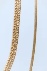 Set de tres collares dorados de diferentes largos. Incluye dos collares de cadena de eslabones metálicos y un collar de cadena tipo malla metálica.