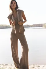 Pantalón de tiro medio color marrón claro, con cintura elástica y tejido con textura.