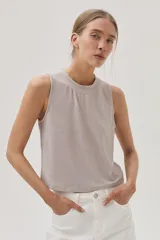 Musculosa color champagne de tejido brillante.