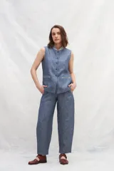 Chaleco azul de lino con cuello mao, abotonado al frente y bolsillos ojal con ribete blanco.