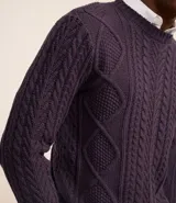 Suéter de punto trenzado color morado oscuro, con cuello redondo y mangas largas.