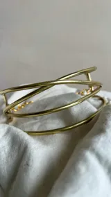 Gargantilla artesanal de bronce con cuatro hilos cruzados. Incluye cadena de acero inoxidable y gancho para regular el largo.