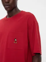 Remera azul marino de corte holgado con bolsillo en el pecho y bordado de Mickey Mouse.