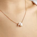 Collar dorado con dije de flor de nácar y mariposa con incrustaciones de strass.