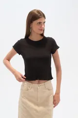 Remera negra de algodón con punto canalé, corte entallado y cuello a la base.