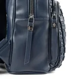 Mochila azul de cuero sintético con diseño tejido. Tiene un compartimento principal con cierre de solapa, un bolsillo interno con cierre y otro abierto. La correa es regulable y los herrajes son plateados.