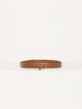 Cinturón marrón de cuero vacuno liso con hebilla y puntera metálica dorada. Aplique de mini lipstick y medialuna.