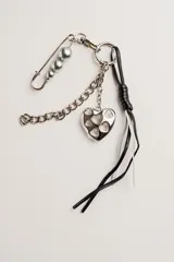 Llavero plateado con dije de corazón calado, cadena de eslabones, imperdible con perlas y tiras de cuero sintético negro y blanco.