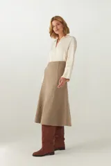 Falda midi evasé color beige, tejida en lana fina con detalle de pespuntes y cierre oculto.
