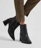 Pantalón legging negro de poliéster con elastano, corte ajustado, cintura alta y aberturas en los tobillos.
