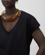 Camiseta negra de algodón orgánico, corte holgado, cuello en V y mangas cortas con hombro caído.