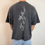 Remera negra con efecto gastado y estampado abstracto en la espalda. Corte boxy y mangas cortas.