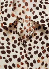 Camisa de manga larga con estampado de manchas marrones y beige sobre fondo blanco.