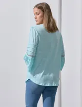 Blusa color celeste con escote en V, mangas largas acampanadas con detalle de crochet.