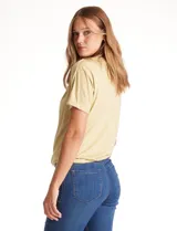 Remera color amarillo claro de modal, marca Philosophy, con cuello volcado y manga corta.