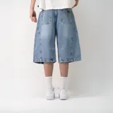 Bermuda de jean celeste con corte ancho y diseño con costuras curvas en los laterales.