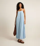Vestido largo celeste de jeans con breteles finos, escote cuadrado, lazo en la espalda y abertura en la parte inferior.
