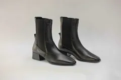 Botas de cuero negro con elástico lateral y taco cuadrado.