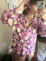 Camisa de manga larga con estampado floral en tonos morado, rosa y amarillo.