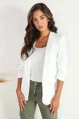 Blazer blanco con solapas, mangas 3/4 fruncidas y bolsillos delanteros.