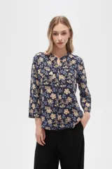 Camisa de viscosa con estampado floral en tonos azul, beige y blanco. Tiene cuello mao, mangas largas y bolsillos en el pecho.